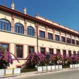 L�edificio richiama comunque alcuni dei canoni classici del Ventennio, come la ripartizione quasi militare della sua parte laterale. Quest�ultima si presenta con un prospetto allungato le cui linee di fuga risultano raddoppiate grazie al doppio ordine delle finestre